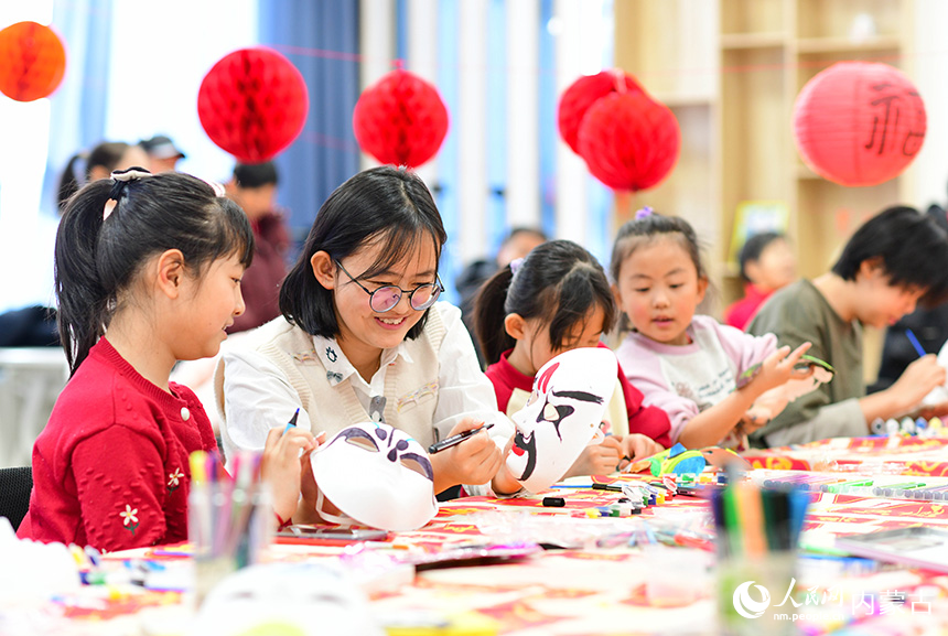 小朋友在康巴什區(qū)園丁社區(qū)畫(huà)臉譜。王正攝