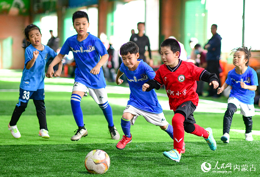 呼和浩特市賽罕區(qū)銀河小學(xué)參賽球員（紅色運(yùn)動(dòng)服）在比賽中。王正攝